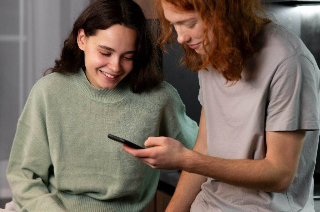 a person in love laughing while looking at their partner's messages