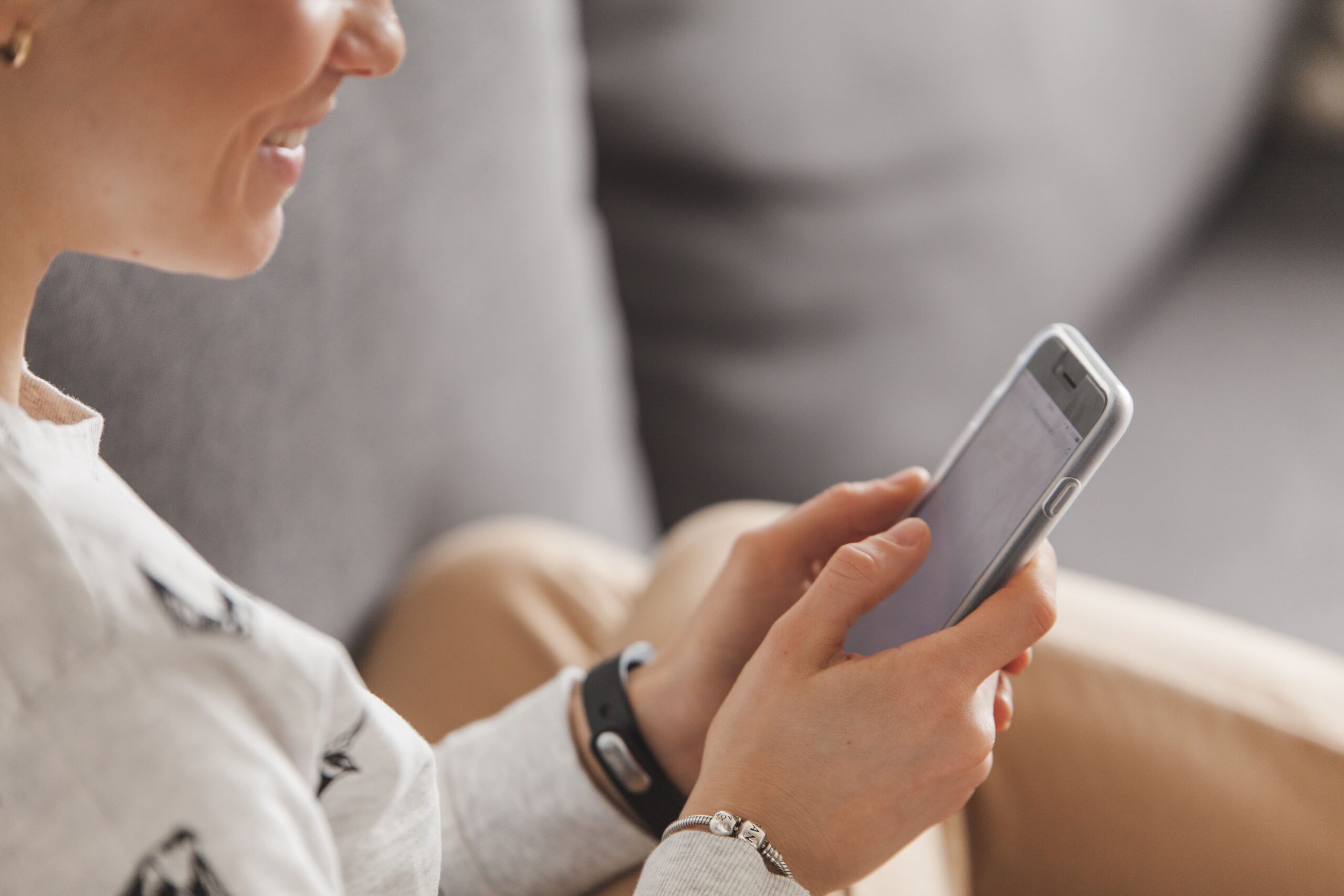 Young woman smiling at her phone after receiving a romantic good morning text