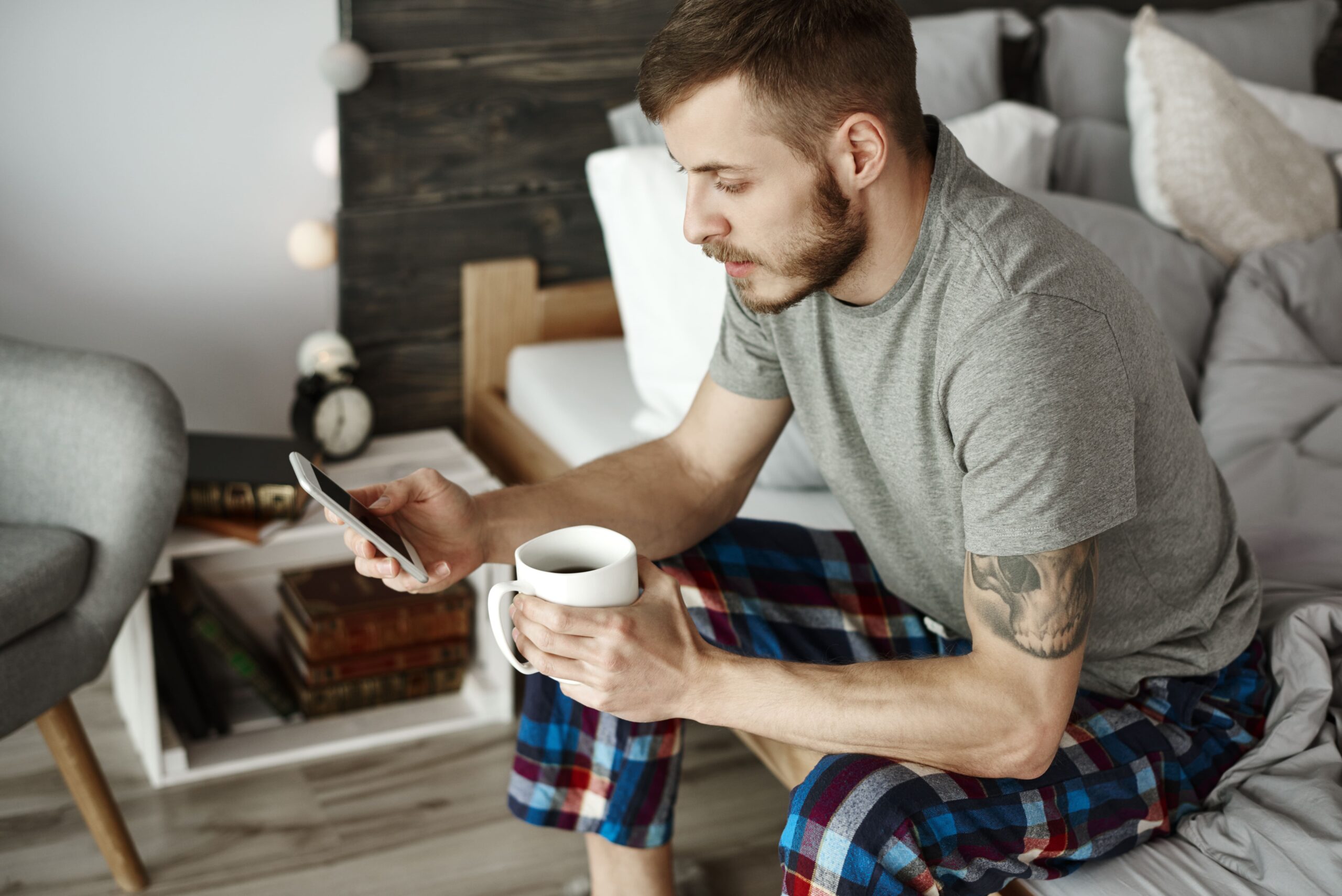 Good morning messages for him that touches the heart Man smiling while reading a heartfelt good morning message from his partner