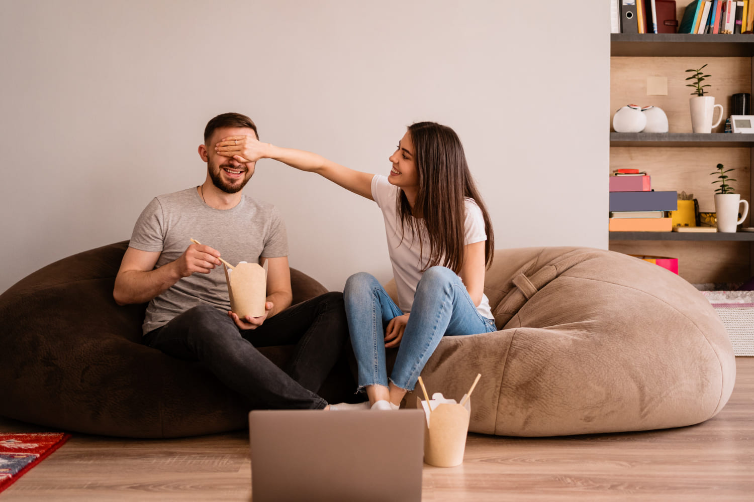 Fun newlywed question games for couples A smiling couple sitting on the couch playing a question game together